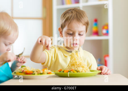 Les enfants mangent des aliments sains à l'école maternelle Banque D'Images