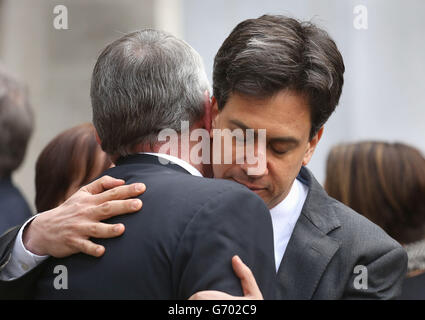 Hilary Benn (à gauche) le fils de l'ancien ministre travailliste Tony Benn étant embrassé par Ed Miliband devant l'église St Margare, Westminster, centre de Londres, après les funérailles de Tony Benn. Banque D'Images