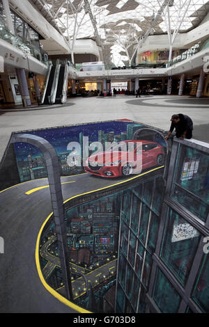 Un grand paysage urbain, avec la toute nouvelle Mazda3 créée par les artistes de rue 3D Joe et Max, au centre commercial Westfield de Londres à Shepherds Bush. Banque D'Images