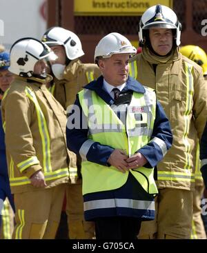 Le premier ministre écossais (au centre), avec le maître-feu Brian Sweeney (à l'arrière-plan à droite), visite le site d'une explosion d'usine à Glasgow qui a fait sept morts.Jack McConnell a rencontré les chefs des services de police, d'incendie et d'ambulance pour leur travail de sauvetage infatigable à la suite de l'explosion d'hier à Stockline Plastics, dans la région de Maryhill à Glasgow.Le premier ministre vient de parler aux survivants de la catastrophe à l'infirmerie de l'Ouest de la ville et aux familles des victimes qui attendent des nouvelles de leurs proches dans un centre communautaire local. Banque D'Images