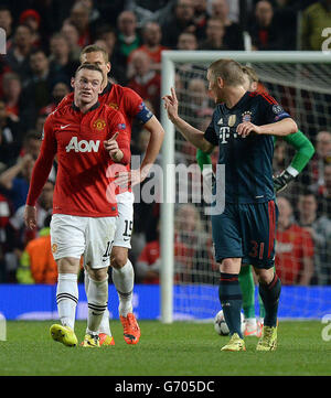 Le Bastian Schweinsteiger de Bayern Munich (à droite) se défend avec Wayne Rooney de Manchester United après avoir reçu une carte rouge de l'arbitre Carlos Velasco Carballo, lors du match final du quart de la Ligue des champions de l'UEFA Old Trafford, Manchester. Banque D'Images