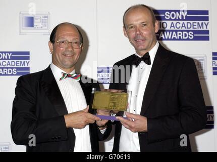 L'entraîneur de rugby d'Angleterre Clive Woodward (à droite) présente le commentateur de radio 5 en direct Ian Robertson avec le prix 2003 lors des Sony radio Academy Awards 2004, qui se tiennent à l'hôtel Grosvenor House sur Park Lane, Londres.La cérémonie a vu Jonathan Ross et Chris Moyles de radio 1 perdre à Christian O'Connell de XFM, qui a été nommé DJ de l'année. Banque D'Images