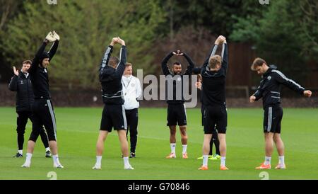 Football - UEFA Champions League - quart de finale - deuxième étape - Chelsea / Paris Saint-Germain - Chelsea Training - Cobham train....Ashley Cole de Chelsea (au centre) balance ses bras pour se réchauffer pendant une séance d'entraînement au terrain d'entraînement de Cobham, Surrey. Banque D'Images