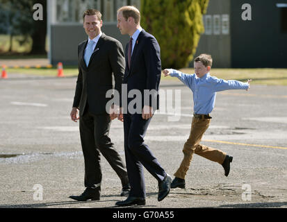 Un jeune garçon tente de se maintenir pendant que le duc de Cambridge parle avec Damian Camp, directeur général de Pacific Aerospace lors d'une visite à Pacific Aerospace à l'aéroport de Hamilton pendant le sixième jour de la tournée officielle du duc et de la duchesse de Cambridge en Nouvelle-Zélande. Banque D'Images