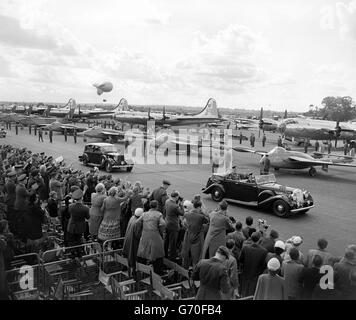 Conduite dans une voiture à toit ouvert après une ligne de Havilland DH.112 Venom avions Fighters avec des B-29 Superforteresses américaines en arrière-plan, la reine Elizabeth II, accompagnée du duc d'Édimbourg, effectue la Coronation Review of the Royal Air Force, à la station RAF, Odiham, Hampshire. Avec plus de 318 avions au sol, et plus de 600 prenant part à un vol passé, l'examen a été le plus grand défilé d'avions dans l'histoire du service. Banque D'Images