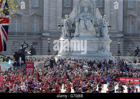 Les coureurs se rendent dans le Mall, sous le Victoria Memorial, à l'extérieur de Buckingham Palace, en direction de la ligne d'arrivée du Virgin Money London Marathon sur le Mall, Londres. Banque D'Images