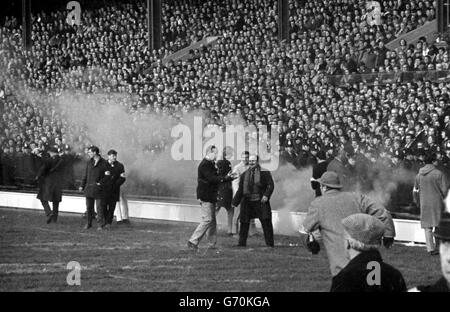 Une bombe à fumée orange est lancée sur le terrain par des manifestants anti-apartheid, lors du match final de la tournée en cours en Afrique du Sud, contre les Barbarians à Twickenham. Banque D'Images