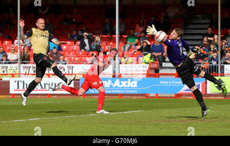 Andy Drury (au milieu), de Crawley Town, dirige le ballon après Jamie Jones, gardien de but Leyton Orient, pour marquer son deuxième but. Banque D'Images