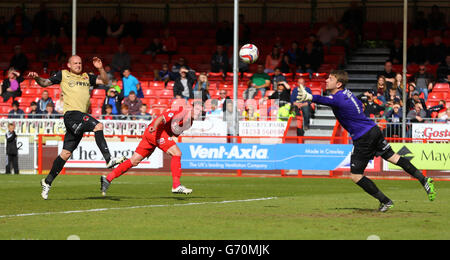 Andy Drury (au milieu), de Crawley Town, dirige le ballon après Jamie Jones, gardien de but Leyton Orient, pour marquer son deuxième but. Banque D'Images