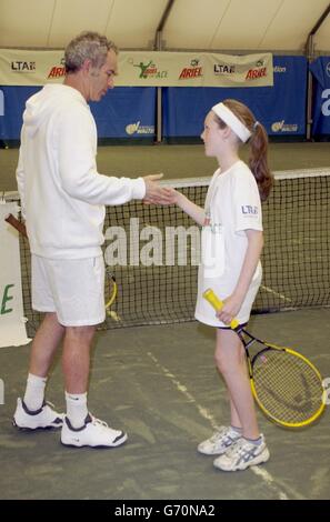 John McEnroe, légende du tennis, est un champion et aide Ariel tennis Ace Lana Doran, de Birmingham, à préparer les grandes finales de Wimbledon le 14 juin, à la Lawn tennis Association Academy. Banque D'Images