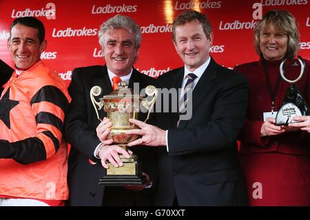 Un Taoiseach Enda Kenny (deuxième à gauche) avec des connexions gagnantes le propriétaire du jockey Davy Russell Gerry McGrath et l'entraîneur Jessica Harrington après que Jetson a remporté l'obstacle de la série mondiale Ladbrokes pendant la troisième journée du Festival Punchesttown à l'hippodrome de Punchestown, Co. Kildare, Irlande. Banque D'Images