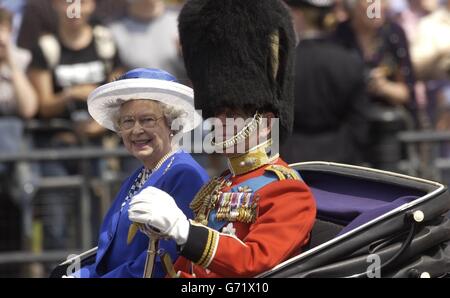 La reine Eliazbeth II de Grande-Bretagne et le duc d'Édimbourg sourient devant la foule lorsqu'ils descendent dans le centre commercial et reviennent de la cérémonie Trooping The Color. L'anniversaire officiel de la Reine a été célébré aujourd'hui, avec le spectacle annuel Trooping the Color. Des milliers de personnes bien-emportant les rues de Whitehall dans le centre de Londres pour profiter de la faste et de la cérémonie de la parade militaire. La Reine et le duc d'Édimbourg voyageront dans une procession de calèches de Buckingham Palace à Horse Guards Parade, où la Reine inspectera les troupes bien-tournées et prendra le salut. Banque D'Images