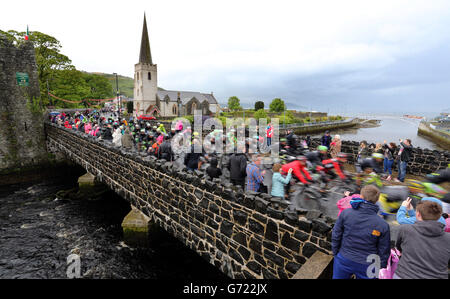 Le peloton traverse le village de Glenarm pendant la deuxième étape du 2014 Giro d'Italia in Co Antrim. Banque D'Images