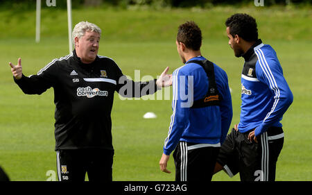 Le directeur de Hull City, Steve Bruce, discute avec Jake Livermore (au centre) et Tom Huddlestone (à droite) lors d'une séance de formation ouverte sur le terrain de formation des équipes à Cottingham, à Hull. Banque D'Images