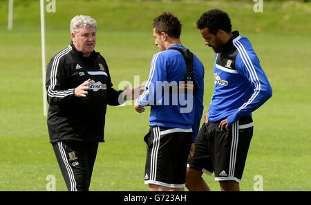 Le directeur de Hull City, Steve Bruce, discute avec Jake Livermore (au centre) et Tom Huddlestone (à droite) lors d'une séance de formation ouverte sur le terrain de formation des équipes à Cottingham, à Hull. Banque D'Images