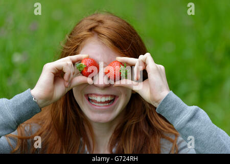 Jeune fille, une adolescente avec des fraises, devant les yeux, Bavière, Allemagne Banque D'Images