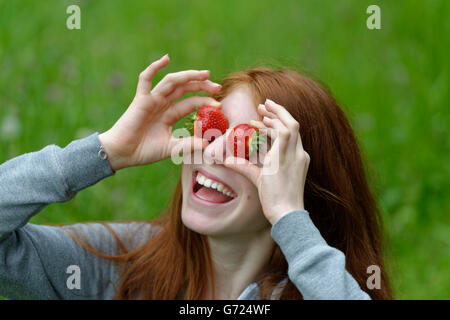 Jeune fille, une adolescente avec des fraises, devant les yeux, Bavière, Allemagne Banque D'Images