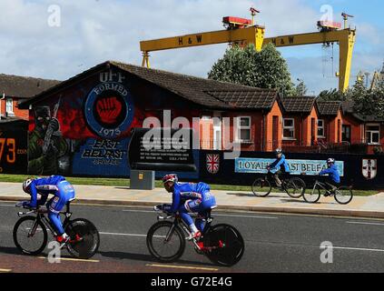 Deux jeunes cyclistes observent les membres de l'équipe de FDJ.fr qui se rendent sur la route Newtownards à Belfast lors de la séance d'essais en temps d'équipe avant la première étape du Giro d'Italia de 2014. Banque D'Images