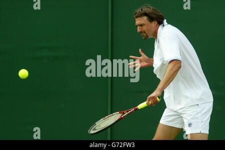 Goran Ivanisevic, de Croatie, en action contre Filippo Volandri, d'Italie, aux championnats de tennis de pelouse à Wimbledon, Londres aujourd'hui jeudi 24 juin 2004. L'ancien champion a lancé son maillot à ses fans après que l'épopée de cinq a terminé 4:6/7:6/1:6/6:3/6:4. , PAS D'UTILISATION DE TÉLÉPHONE MOBILE. Banque D'Images