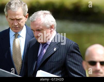 LE président AMÉRICAIN George Bush (à gauche) et l'irlandais Taoiseach Bertie Ahern passent un agent du service secret après avoir assisté à la conférence de presse lors de leur réunion au château de Dromoland, Co Clare, République d'Irlande. Banque D'Images