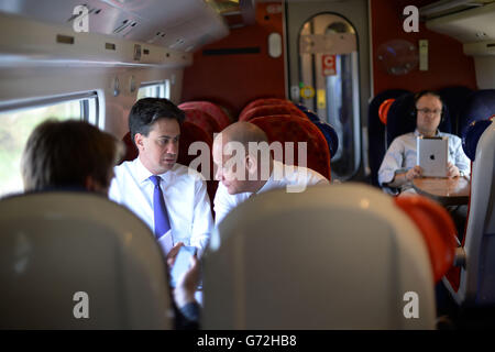 Le leader syndical Ed Miliband s'entretient avec son directeur exécutif des communications Bob Roberts lorsqu'il se rend en train au nord du pays de Galles où il visitera l'usine Airbus de Broughton pendant une journée de campagne pour les élections locales et européennes de la semaine prochaine. Banque D'Images