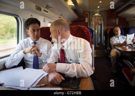 Le leader syndical Ed Miliband s'entretient avec son directeur exécutif des communications Bob Roberts lorsqu'il se rend en train au nord du pays de Galles où il visitera l'usine Airbus de Broughton pendant une journée de campagne pour les élections locales et européennes de la semaine prochaine. Banque D'Images