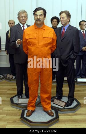 La cire de l'ancien président irakien Saddam Hussein portant un costume d'orange, avec le président américain George W Bush (à gauche) et le Premier ministre britannique Tony Blair à Madame Tussauds dans le centre de Londres. Banque D'Images