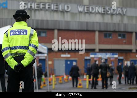 Un policier se tient devant les membres de la presse à l'extérieur du stade Hillsborough à Sheffield, tandis que des jurés sur l'enquête sur la mort de 96 fans de football de Liverpool tués dans le désastre de Hillsborough ont visité le stade aujourd'hui. Banque D'Images