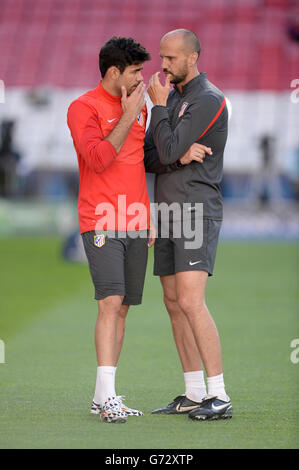 Diego Costa de l'Atletico Madrid semble profondément réfléchi alors qu'il parle avec le physiothérapeute de réadaptation Oscar Pitillas pendant l'entraînement Banque D'Images