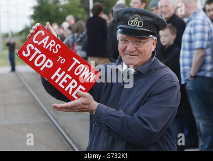 George Broom détient un panneau de l'ancien système de tramway d'Édimbourg qui a cessé de fonctionner en 1956, alors qu'il attend de monter à bord du premier tramway transportant des passagers payants au centre commercial Gyle d'Édimbourg. Banque D'Images