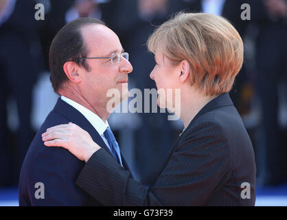 La chancelière allemande Angela Merkel salue le président français François Hollande lors d'une cérémonie internationale avec des chefs d'État à Sword Beach en Normandie pour marquer le 70e anniversaire du débarquement. APPUYEZ SUR ASSOCIATION photo. Date de la photo: Vendredi 6 juin 2014. Voir PA Story MEMORIAL DDay. Le crédit photo devrait se lire: Chris Jackson/PA Wire Banque D'Images