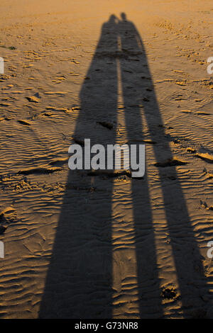 Côté mer ombre jouant avec l'ombre dans le soleil de fin de soirée sur la plage Banque D'Images