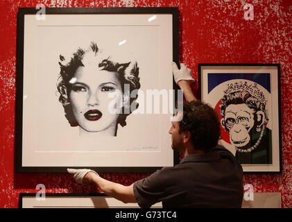 Un travailleur tenant le portrait de Kate Moss (2005) de Banksy à un aperçu de la presse pour l'exposition Banksy: The Unauthorized Retrospective, organisé par Steve Lazarides, à la S|2 Gallery de Londres. Banque D'Images