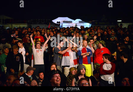 Les fans de l'Angleterre fêtent leur équipe qui marque un but en regardant le match de l'Angleterre contre l'Italie sur des écrans géants, au cours du deuxième jour du Festival de téléchargement 2014 à Donington Park. Banque D'Images