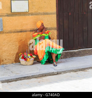 La femme cubaine en robe colorée fumer un cigare à La Habana Vieja, La Vieille Havane, Cuba Banque D'Images