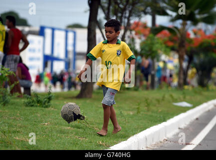 Football - coupe du monde de la FIFA 2014 - Groupe A - Brésil / Mexique - Estadio Castelao.Un jeune fan du Brésil joue au football dans les rues de Fortaleza Banque D'Images