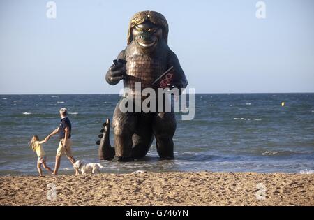 Une créature marine de 25 pieds de haut ressemblant à Richard Branson émerge de la mer sur la plage de Bournemouth à Dorset, avec un téléviseur, un ordinateur portable, un téléphone et un mobile pour célébrer le lancement de l'ensemble Big Kahuna de Virgin Media. Banque D'Images