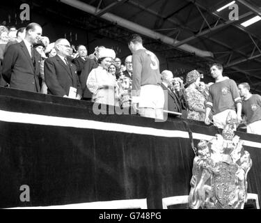 La Reine, vêtue de laine bleue de Cambridge avec un chapeau de pétale assorti, présente la coupe FA à Noel Cantwell, à gauche et capitaine de Manchester United, à Wembley. Accompagnée par le duc d'Édimbourg, elle avait regardé United battre Leicester City 3-1 en finale de la coupe. Banque D'Images