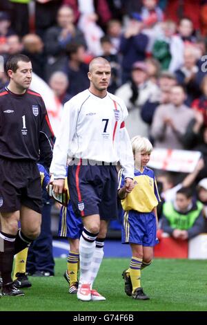 Le capitaine d'Angleterre David Beckham dirige son équipe, suivi du gardien de but Nigel Martyn (à gauche) lors du match international national contre la Suède à Old Trafford, Manchester. Banque D'Images