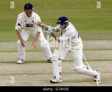 Mike Hussey de Gloucestershire joue un tir défensif loin du joueur du Lancashire Iain Sutcliffe du bowling de James Anderson lors de leur match de championnat du comté de Frizzell au Cheltenham College. Banque D'Images