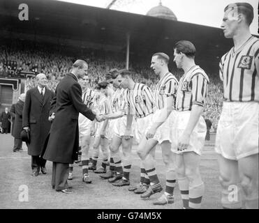 Le duc d'Édimbourg serre la main avec le bak gauche Peter Aldis alors que les joueurs de l'Aston Villa lui sont présentés sur le terrain à l'Empire Stadium, Wembley, avant le début de la finale de la coupe FA contre Manchester United, les champions de la ligue.Villa a déçu les espoirs de United de faire sortir la coupe de la Ligue deux fois en remportant le match 2-1. Banque D'Images