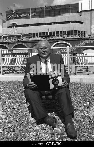 Norman Willis, secrétaire général de TUC, assis sur la plage de Brighton, et un rapport sur l'apartheid, qui doit être discuté au Congrès plus tard dans la semaine. Banque D'Images