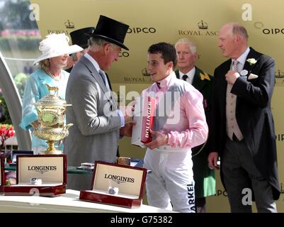 Le Prince de Galles présente le jockey William Buick avec quelques Bollinger après avoir remporté les enjeux du Prince de Galles sur la fugue pendant le deuxième jour de la réunion royale d'Ascot de 2014 à l'hippodrome d'Ascot, dans le Berkshire. Banque D'Images