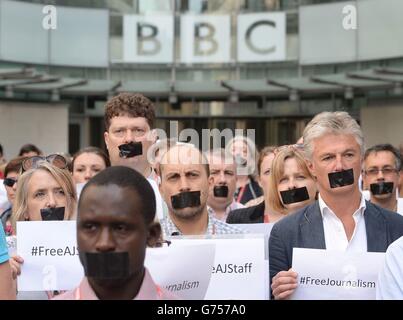 Le personnel et les journalistes de la BBC protestent devant la New Broadcasting House à Londres en faisant remonter leur bouche sur l'emprisonnement en Égypte des journalistes Peter Greste, Mohamed Fahmy et Baher Mohamed. Banque D'Images