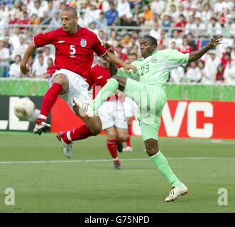 Le Rio Ferdinanad d'Angleterre bat Femi Opabunmi du Nigeria au ballon lors de leur finale coupe du monde du Groupe F au stade Nagai, Osaka. Eiwc Banque D'Images