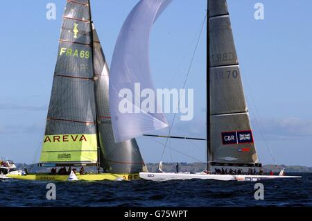 L'équipe britannique de la coupe de l'Amérique GBR Challenge (à droite) traverse la ligne d'arrivée dans le golfe d'Hauraki au large d'Auckland, en Nouvelle-Zélande, tandis que le bateau français le Defi Areva exécute une pénalité sur la ligne. Gagnant de seulement 13 secondes, il a été le premier point de GBR dans trois courses. Banque D'Images