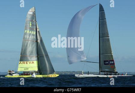 L'équipe britannique de la coupe de l'Amérique GBR Challenge (à droite) traverse la ligne d'arrivée dans le golfe d'Hauraki au large d'Auckland, en Nouvelle-Zélande, tandis que le bateau français le Defi Areva exécute une pénalité sur la ligne. Gagnant de seulement 13 secondes, il a été le premier point de GBR dans trois courses. Banque D'Images