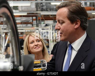 Le ministre de l'emploi et des déficiences, Esther McVey, regarde le Premier ministre David Cameron lors d'une visite de la chaîne de production de Brompton Bicycle Ltd à Brentford, Middlesex. Banque D'Images