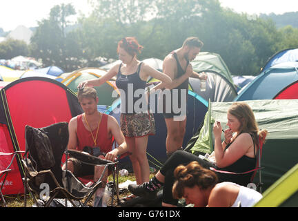 Les festivaliers passent leurs routines matinales à l'extérieur de leurs tentes, au Glastonbury Festival, à la ferme digne de Somerset. Banque D'Images