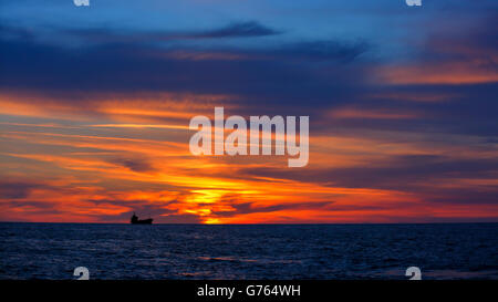 Beau paysage, orange spectaculaire coucher de soleil sur la mer, bateau silhouette sur fond de ciel du soir, la beauté de l'été nature Banque D'Images